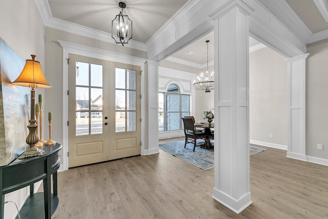 foyer entrance featuring an inviting chandelier, crown molding, and french doors