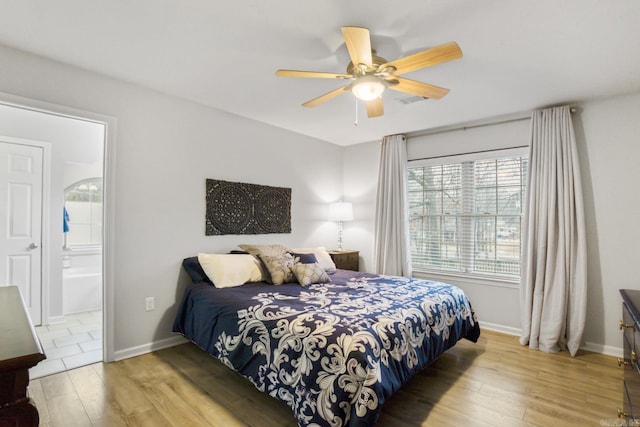 bedroom featuring ceiling fan, light hardwood / wood-style floors, and ensuite bath