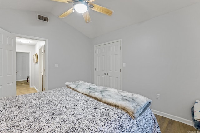 bedroom with vaulted ceiling, hardwood / wood-style floors, ceiling fan, and a closet