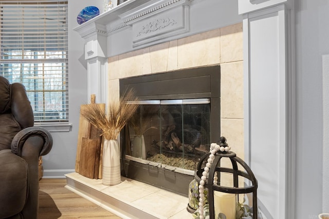 room details with hardwood / wood-style flooring and a tiled fireplace