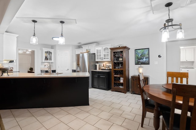 kitchen with sink, hanging light fixtures, stainless steel refrigerator with ice dispenser, white cabinets, and washer / dryer