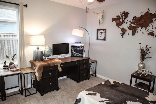 carpeted home office featuring ceiling fan