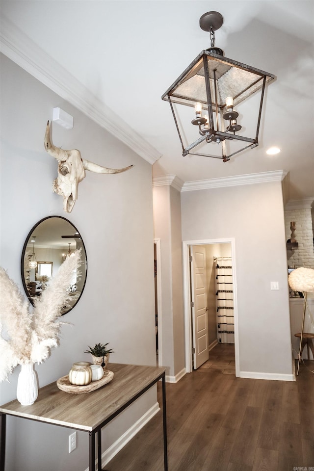 hall featuring crown molding, dark hardwood / wood-style flooring, and a chandelier