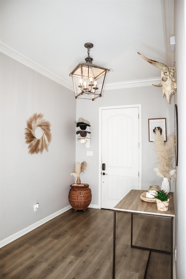 foyer with ornamental molding, dark hardwood / wood-style floors, and a notable chandelier