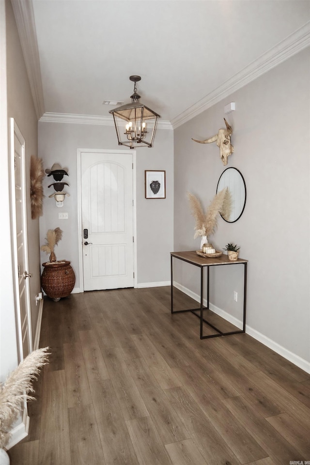 foyer entrance featuring crown molding, dark hardwood / wood-style flooring, and a notable chandelier