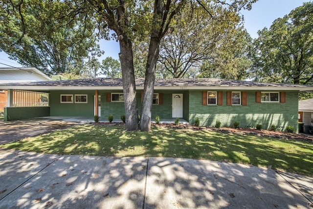 single story home featuring brick siding, an attached carport, driveway, and a front lawn