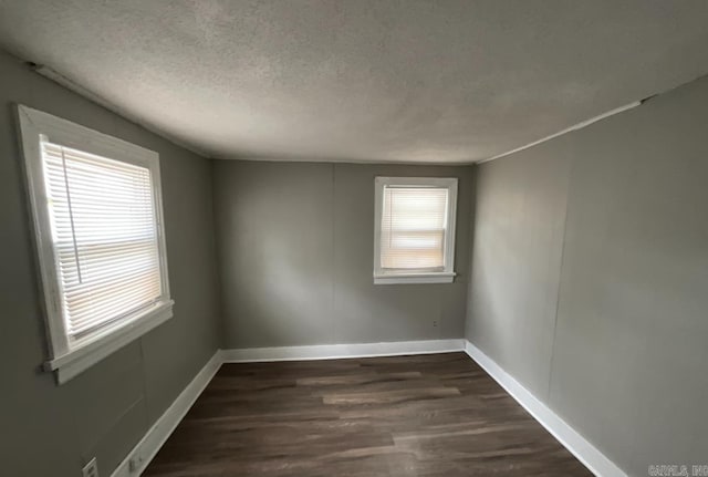 unfurnished room with dark hardwood / wood-style floors and a textured ceiling