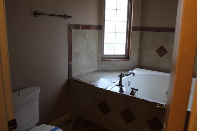 bathroom featuring a tub to relax in and toilet