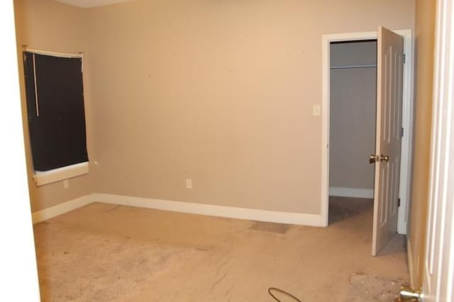 unfurnished bedroom featuring light carpet and a closet