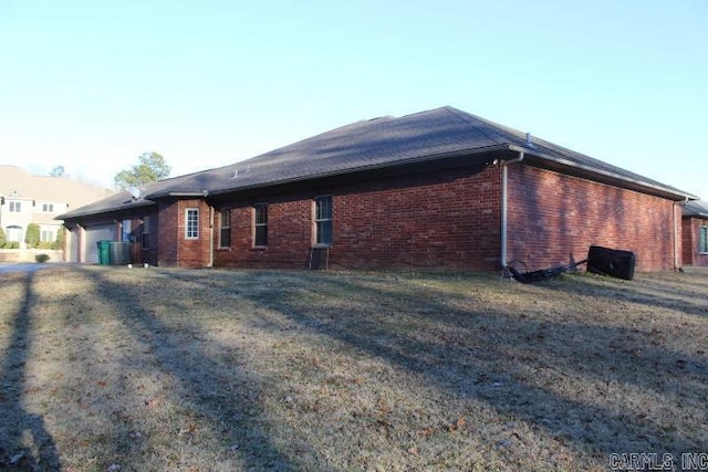 view of side of home featuring a garage and a yard