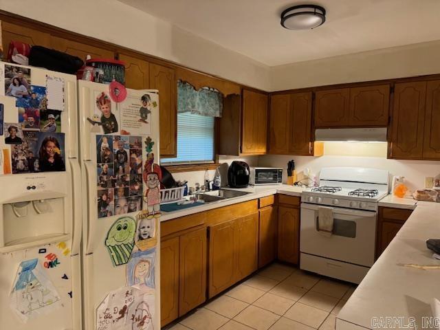 kitchen featuring light tile patterned floors and white appliances