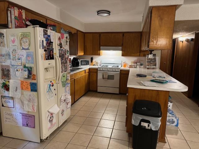 kitchen with light tile patterned floors and white appliances