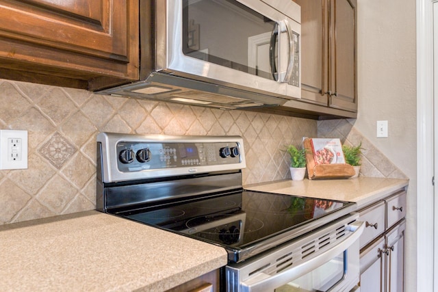 kitchen with decorative backsplash and appliances with stainless steel finishes