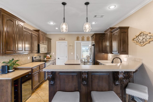 kitchen featuring stainless steel appliances, a breakfast bar area, and dark brown cabinetry