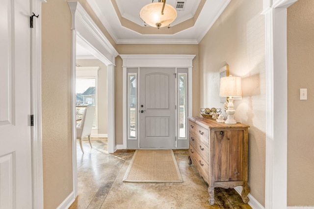 foyer with crown molding and a raised ceiling