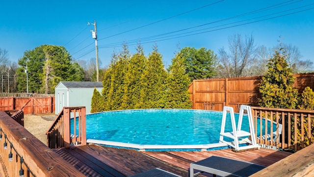 view of pool with a deck and a shed