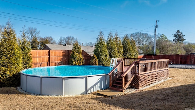 view of swimming pool featuring a yard and a deck