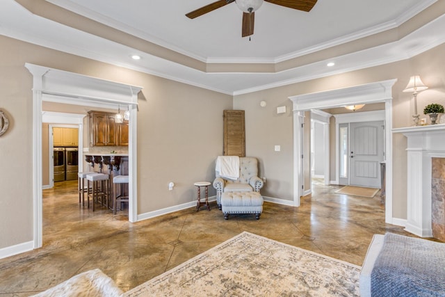 living area featuring separate washer and dryer, crown molding, a raised ceiling, and ceiling fan