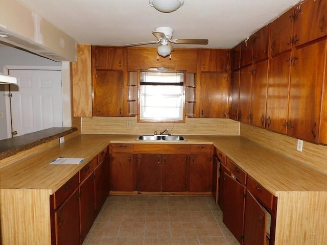 kitchen featuring sink, backsplash, ceiling fan, and kitchen peninsula