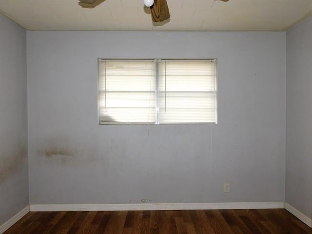 spare room with dark wood-type flooring and ceiling fan