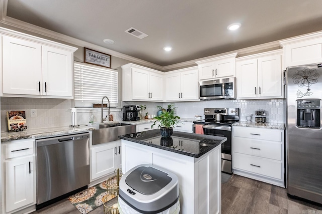 kitchen featuring sink, stainless steel appliances, a center island, and white cabinets