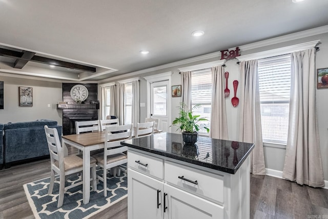 kitchen featuring crown molding, a kitchen island, white cabinets, and dark hardwood / wood-style flooring