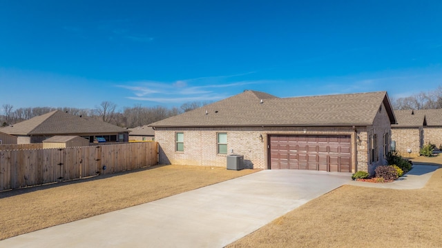 view of front of home featuring central AC unit, a garage, and a front lawn