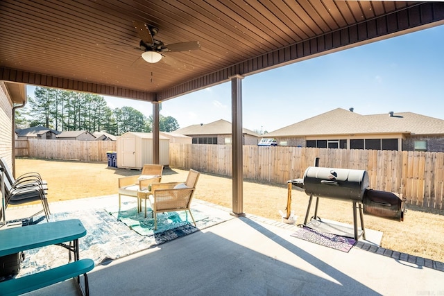 view of patio with a grill, ceiling fan, and a shed