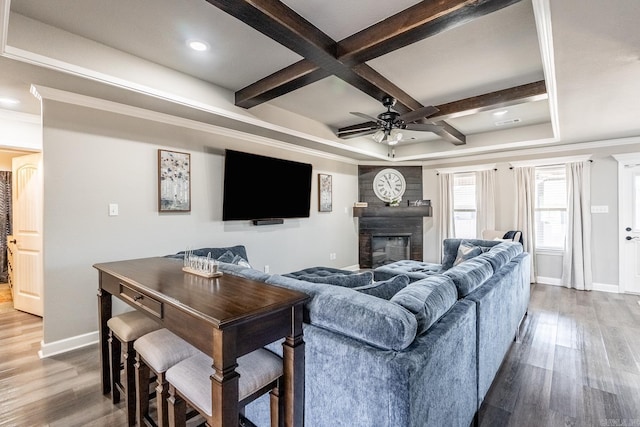 living room with hardwood / wood-style flooring, ceiling fan, beam ceiling, coffered ceiling, and a large fireplace