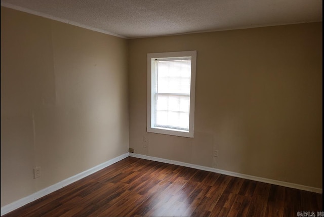 empty room with dark wood-type flooring and a textured ceiling