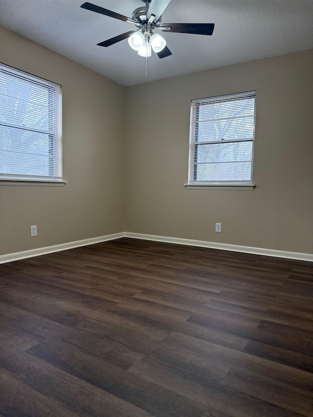 unfurnished room featuring dark hardwood / wood-style flooring, ceiling fan, a textured ceiling, and a healthy amount of sunlight