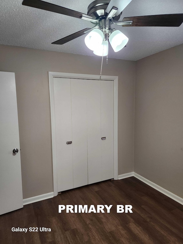 unfurnished bedroom featuring ceiling fan, dark hardwood / wood-style floors, a textured ceiling, and a closet