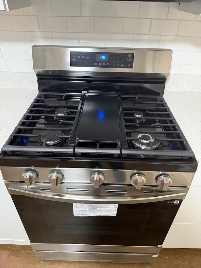 room details with stainless steel range with gas cooktop and backsplash