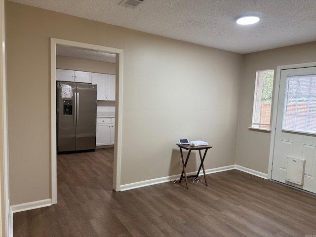 foyer entrance featuring dark wood-type flooring and a textured ceiling