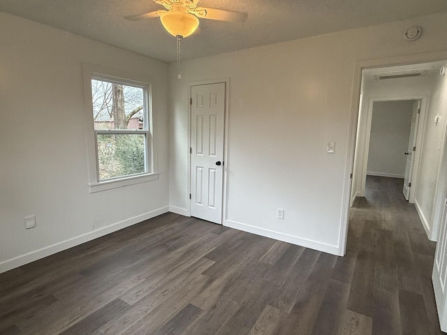 empty room featuring dark hardwood / wood-style floors, a textured ceiling, and ceiling fan