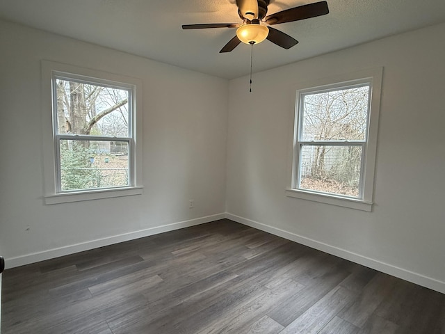 spare room with ceiling fan and dark hardwood / wood-style flooring