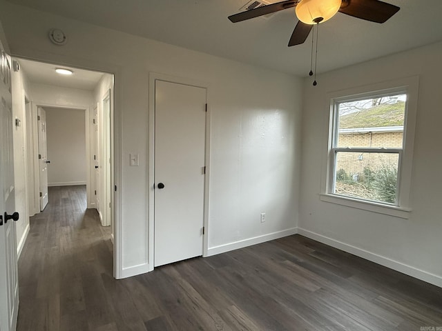 unfurnished bedroom with ceiling fan and dark hardwood / wood-style flooring