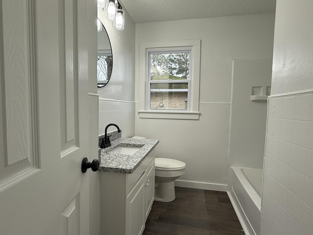 full bathroom with toilet, bathing tub / shower combination, a textured ceiling, vanity, and hardwood / wood-style flooring