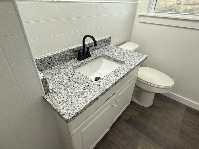 bathroom featuring vanity, wood-type flooring, and toilet