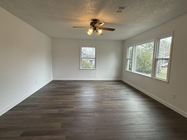 spare room featuring dark hardwood / wood-style floors, a textured ceiling, and ceiling fan