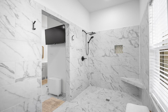 bathroom with vanity and a tile shower