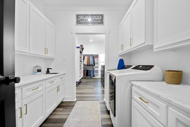 clothes washing area with sink, crown molding, independent washer and dryer, cabinets, and dark hardwood / wood-style flooring