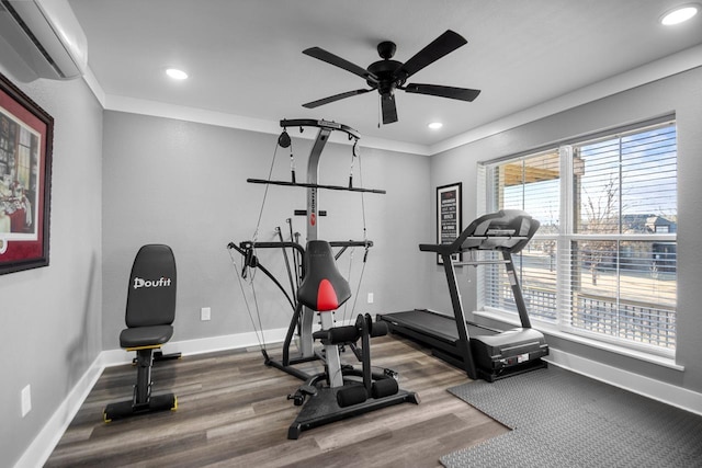 exercise area featuring wood-type flooring, ornamental molding, and a wall unit AC