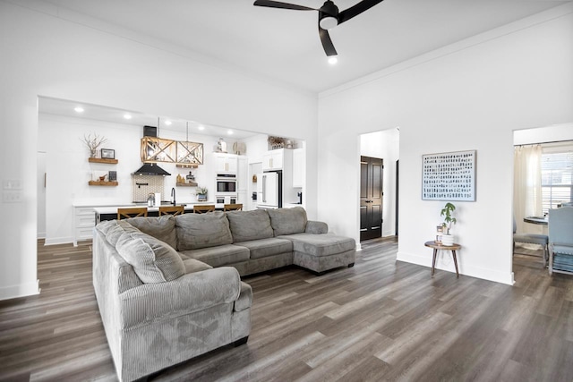 living room with crown molding, sink, ceiling fan, and dark hardwood / wood-style flooring