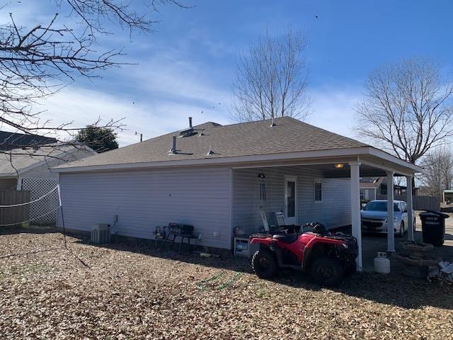 rear view of property with cooling unit and a carport