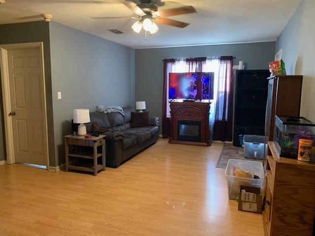 living room with light hardwood / wood-style floors and ceiling fan