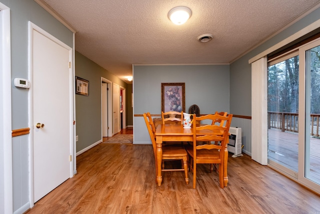 dining room with ornamental molding, light hardwood / wood-style floors, and heating unit