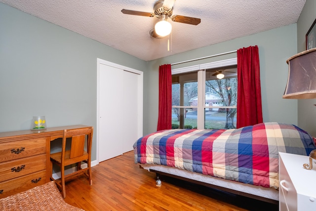 bedroom featuring ceiling fan, a closet, wood-type flooring, and a textured ceiling