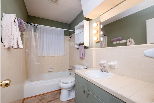 full bathroom with shower / tub combo, tile walls, vanity, a textured ceiling, and toilet