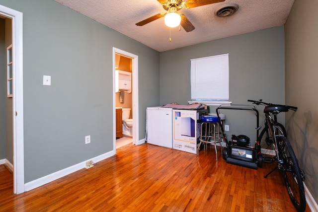 misc room with hardwood / wood-style floors, a textured ceiling, and ceiling fan